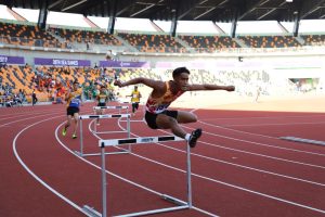 a person jumping over hurdles on a track