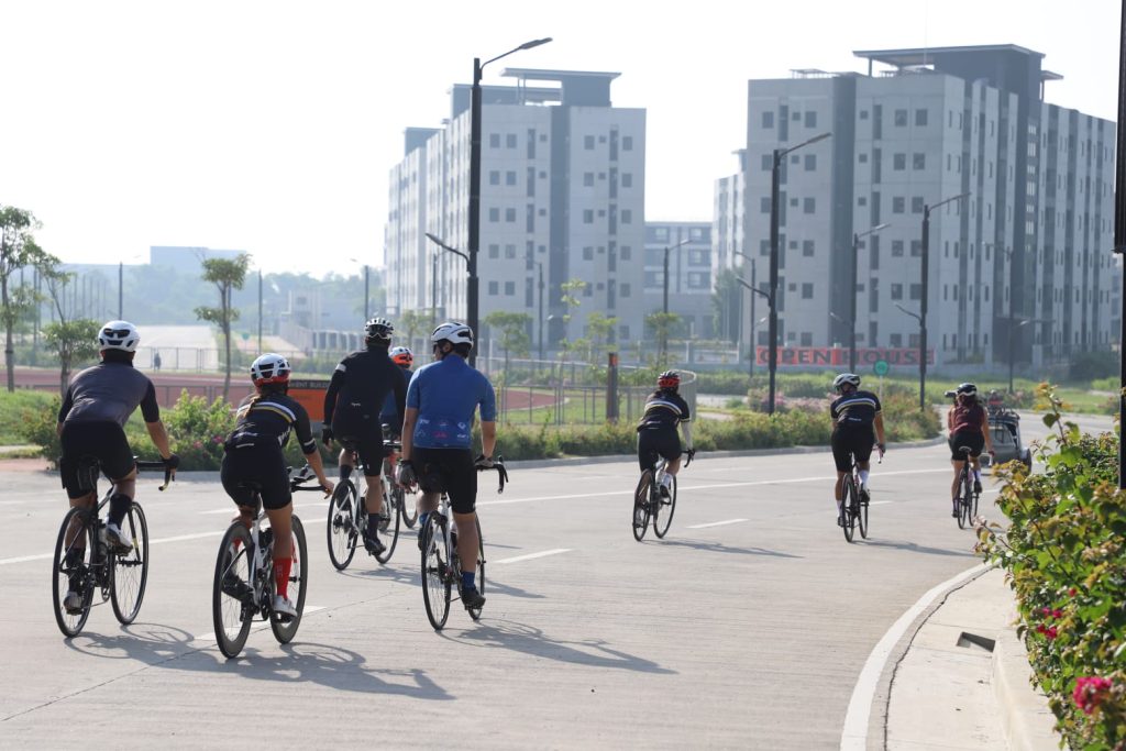a group of people riding bicycles on a road