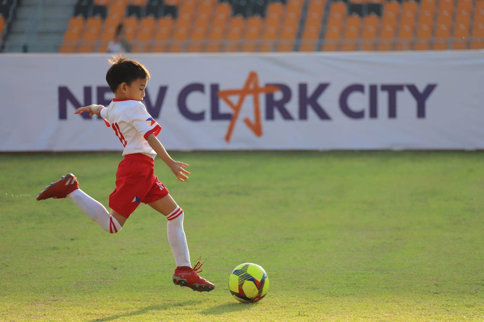 a child kicking a football ball