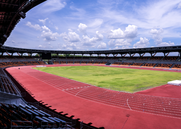 a stadium with a running track and a green field