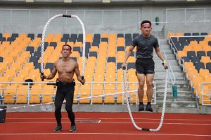 two men jumping rope in a stadium