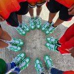 a group of people wearing green and white shoes